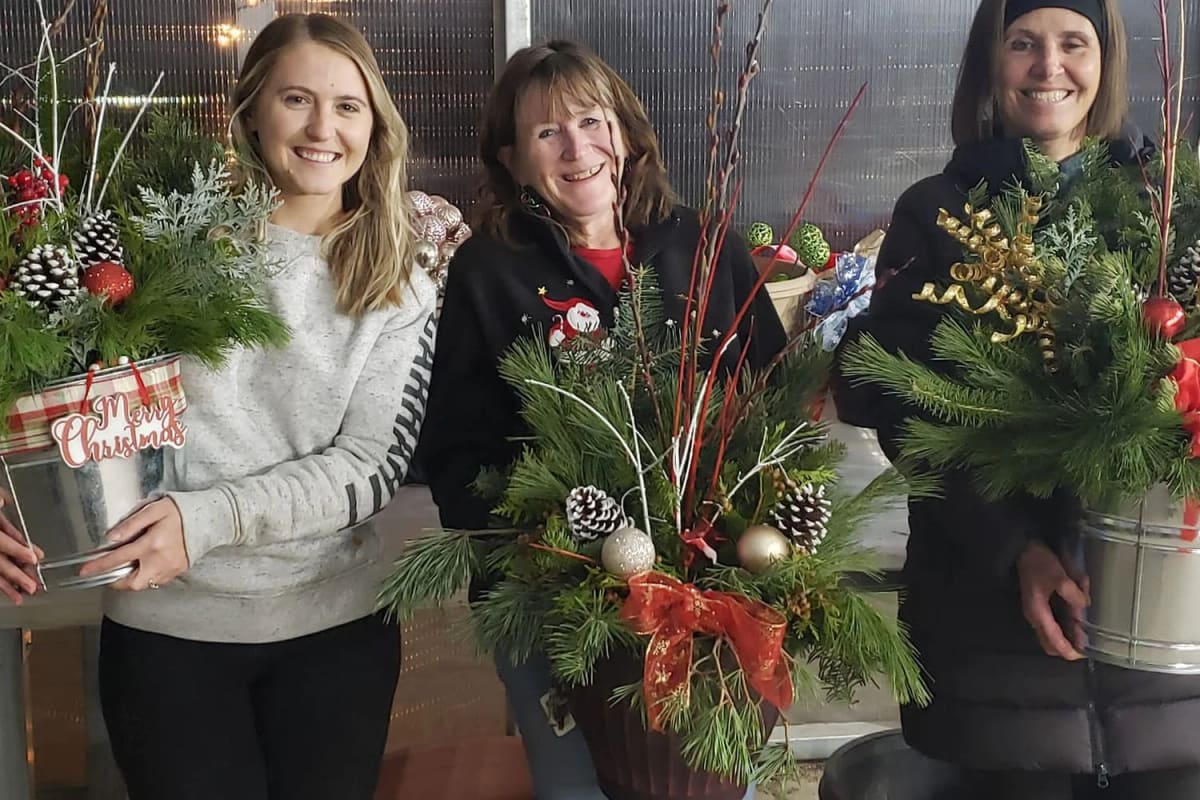 Guests building their own evergreen containers at a Christmas container class