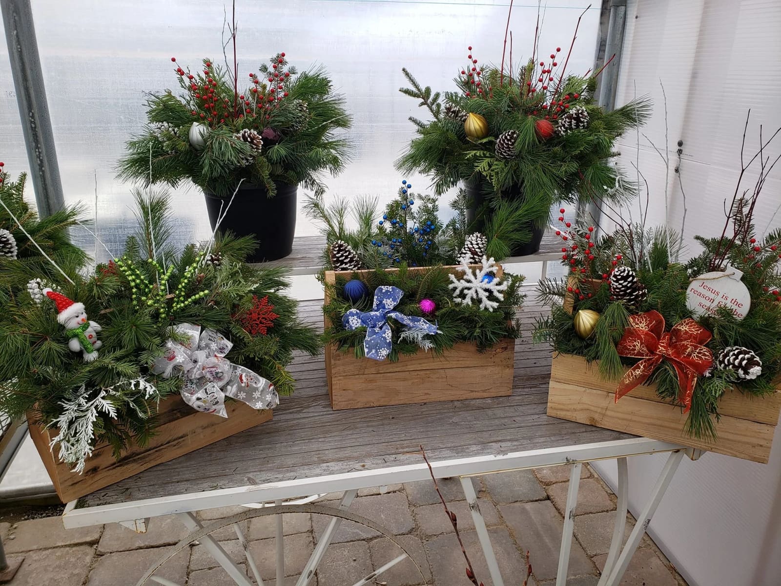 Fresh evergreen Christmas containers and wreaths made at Paul's Petal Pushers